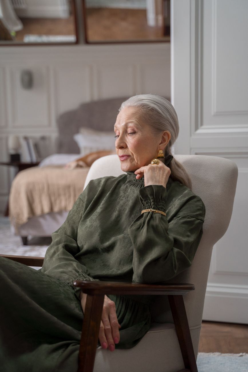 An older woman sitting comfortably in an armchair at home